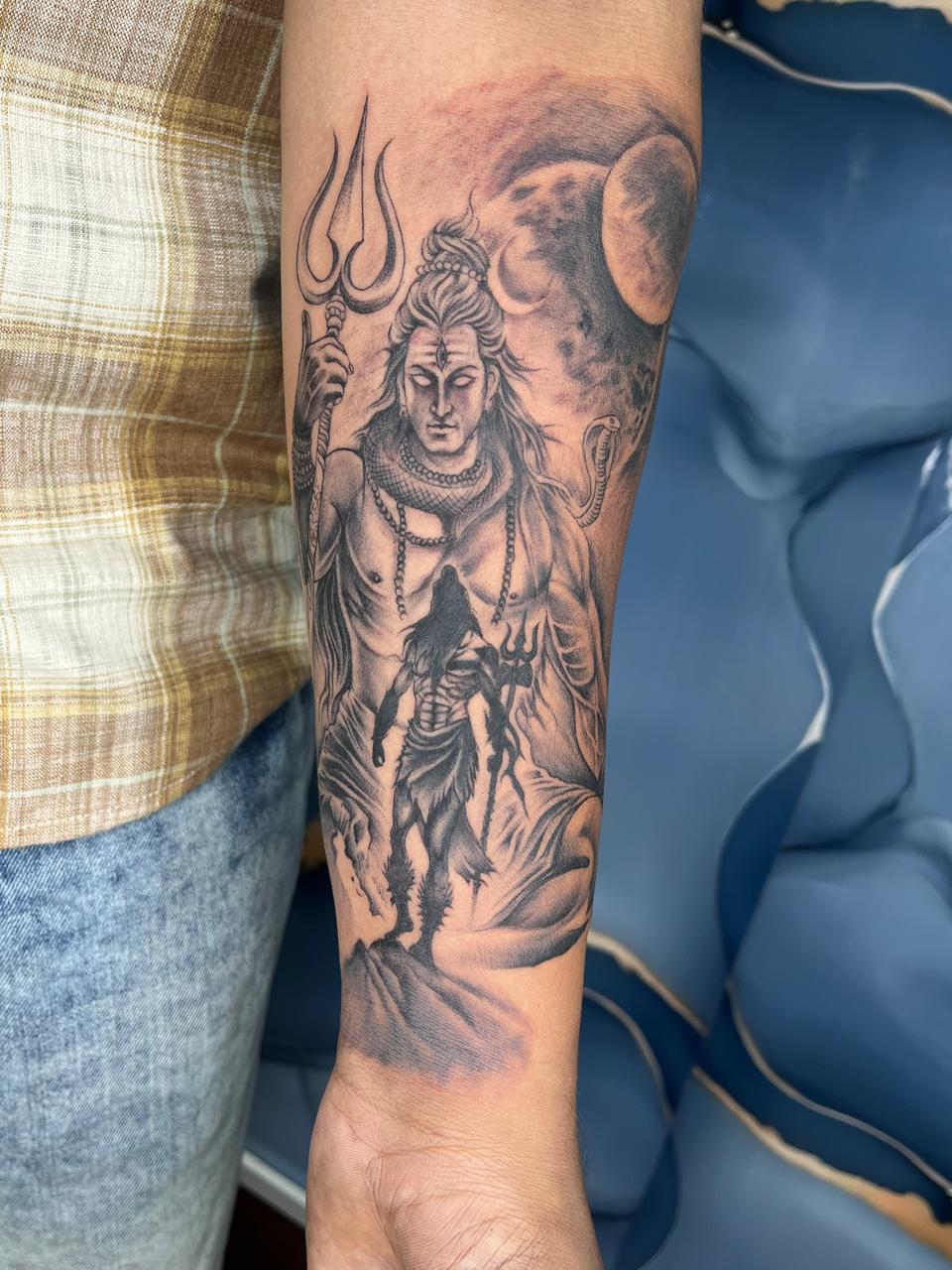 Large-scale Lord Shiva forearm tattoo in black and grey shading at Evil Tattoo Studio, Madhapur, Hyderabad